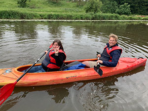 Mitarbeiter der Eresult GmbH in einem Kanu auf einem Fluss.