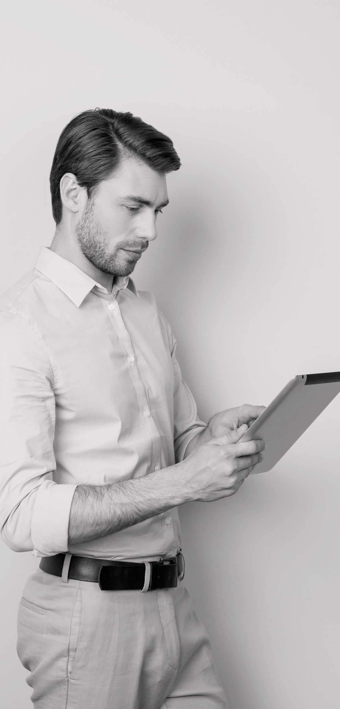 Ein Mann, im Business-Look gekleidet, mit einem Tablet in der Hand